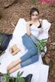 A woman sitting on a blanket in the woods.