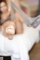 A woman laying on top of a bed with her feet up.