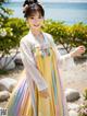 A woman in a colorful dress standing on a beach.