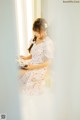 A woman sitting on a window sill reading a book.