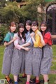 A group of young women standing next to each other in front of a building.