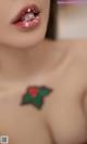 A close up of a woman with a holly tattoo on her chest.