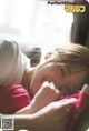 A woman laying on top of a bed next to a window.