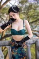 A woman in a green bra and black gloves posing for a picture.