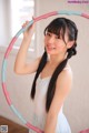 A young woman holding a hula hoop in her hands.