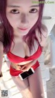A woman in a red bikini holding a cell phone.