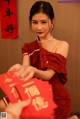 A woman in a red dress holding a red envelope.