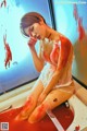 A woman sitting in a bathtub covered in blood.