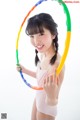 A young girl holding a colorful hula hoop in her hands.