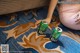 A woman sitting on the floor next to two cans of beer.