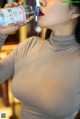 A woman is drinking water from a bottle.