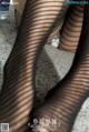 A close up of a woman's legs in fishnet stockings.