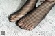 A pair of black fishnet stockings on a white surface.