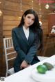 A woman sitting at a table with a plate of fruit.