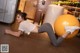 A woman is doing a crunch on an exercise ball.