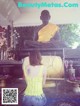 A woman sitting in front of a statue of a buddha.