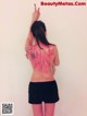 A woman with a tattoo on her back pointing up.