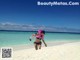 A woman in a bikini and snorkeling gear on a beach.