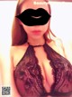 A woman wearing a black lingerie and a black mask.