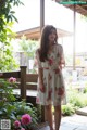 A woman in a white dress standing in a garden.