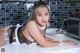 A woman in lingerie laying on a kitchen counter.