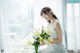 A woman in a white dress holding a bouquet of flowers.