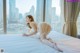 A woman in a white lingerie laying on a bed.