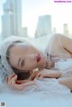 A woman in a wedding dress laying on a bed.