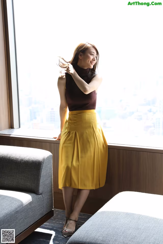 A woman standing in front of a window in a room.