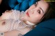 A woman laying on top of a blue couch.