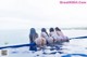 A group of women sitting on the edge of a swimming pool.