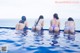 A group of women in bikinis sitting in a swimming pool.