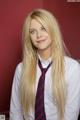 A woman with long blonde hair wearing a tie.