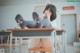 A woman sitting at a desk in a classroom.