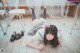 A woman laying on the floor in a classroom.