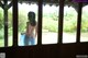 A naked woman standing in front of a window.