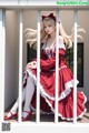 A woman in a red and white dress sitting on a balcony.