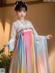 A woman wearing a colorful hanbok is posing for a picture.