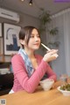 A woman sitting at a table with chopsticks in her hand.